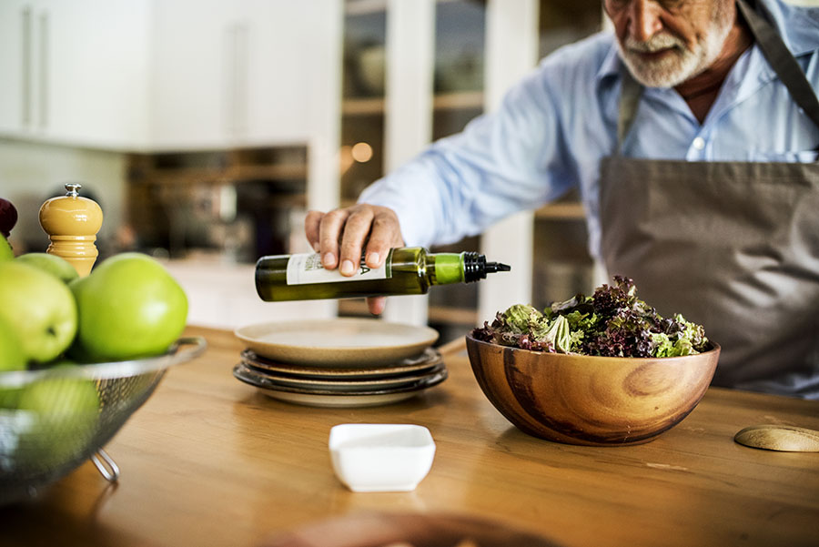 Eine Person hält eine braune Flasche Carbon 60 EVOO.